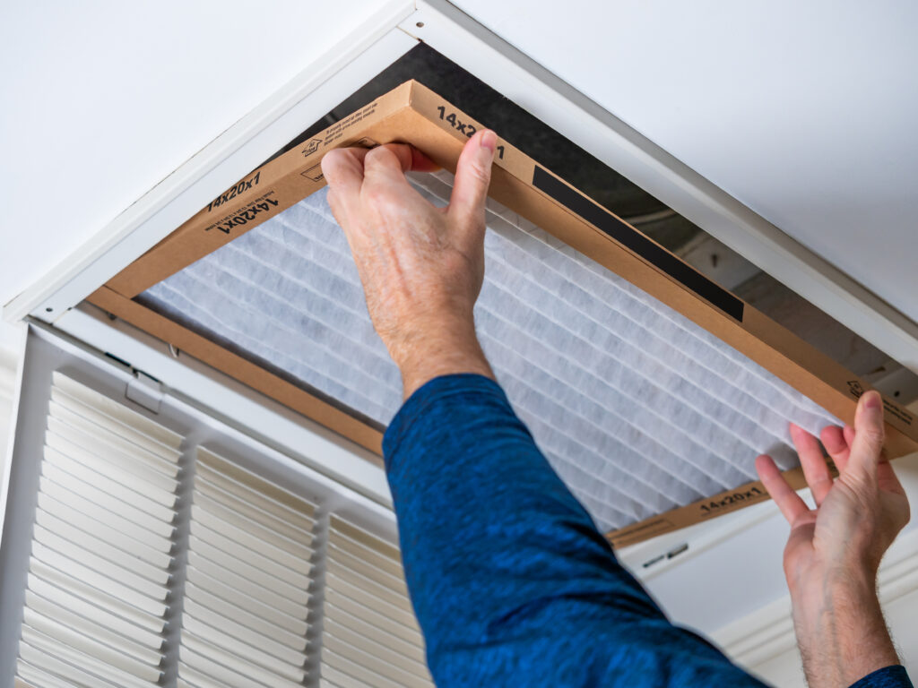 HVAC technician replacing a home air filter in Fremont