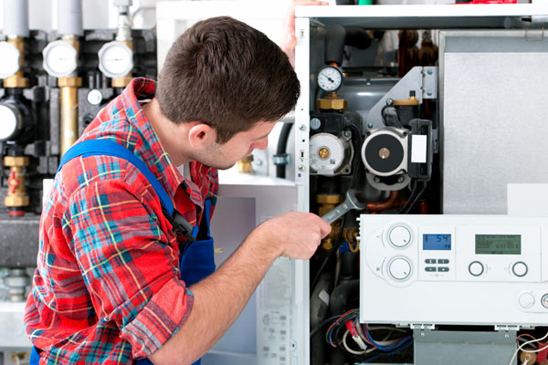 Heating technician repairing boiler controls in Fremont