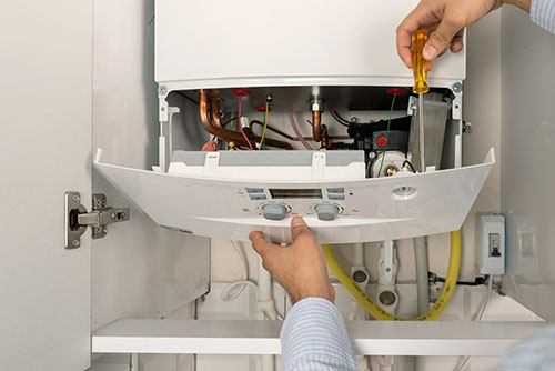 Heating technician repairing a residential boiler in Fremont
