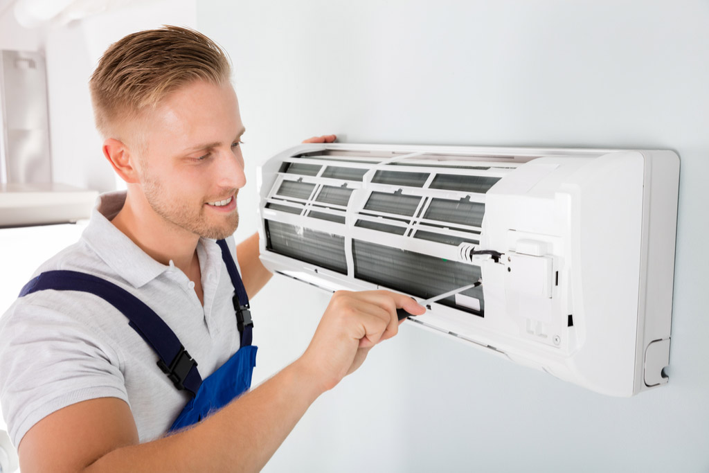 HVAC technician maintaining a ductless air conditioner in Fremont