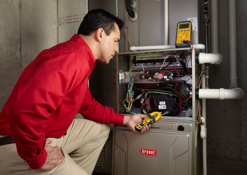 Heating technician diagnosing a furnace repair in Fremont