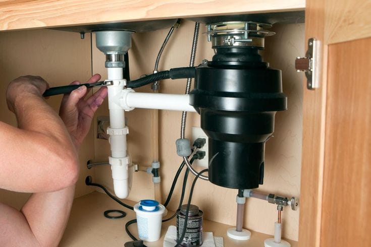 Plumber repairing a garbage disposal in Fremont